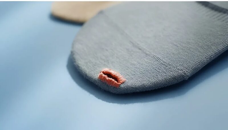 Der Designer präsentierte ein Modell von Socken mit einem Loch am Zeh.